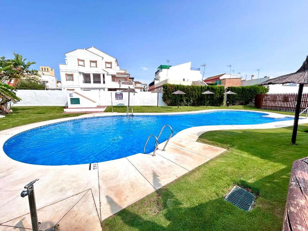 een zwembad in de tuin van een huis bij Apartamento Empul Rota Príncipe in Rota