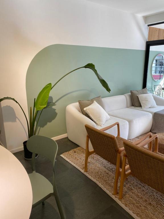 Una sala de estar con un sofá blanco y sillas. en Belgrano-3A, en Buenos Aires