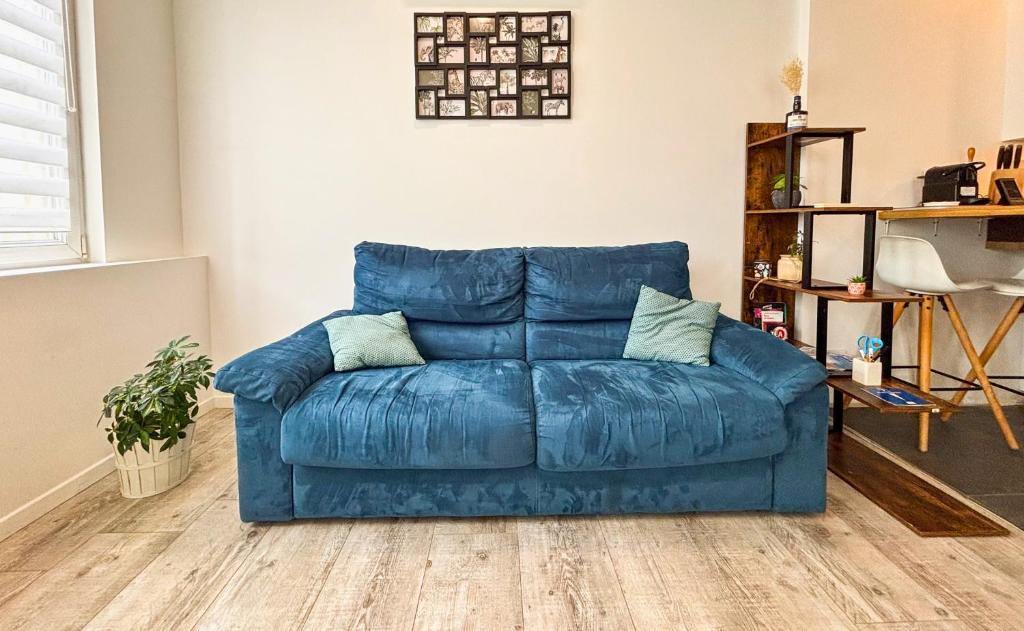 - un canapé bleu dans le salon dans l'établissement Le Souplex - Balnéo & Cosy - Accès Tram Strasbourg - Commerces à Proximité, à Strasbourg