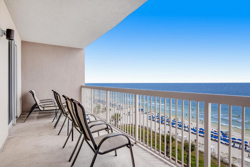 een balkon met stoelen en uitzicht op de oceaan bij Sunrise Beach 906 -Beachfront Condo in Panama City Beach
