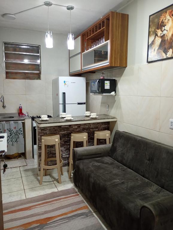 a living room with a couch and a kitchen at Apartamento Completo e Centralizado 4 in Belém