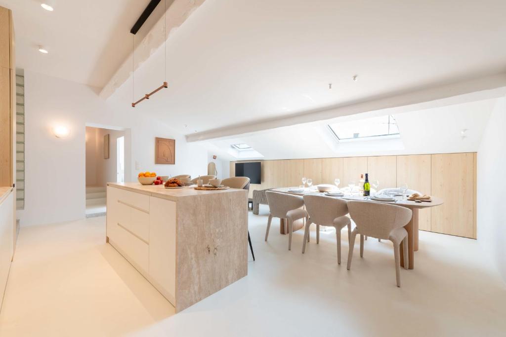 une cuisine et une salle à manger avec une table et des chaises dans l'établissement 3-Br Attic Duplex Heart of Cannes, à Cannes