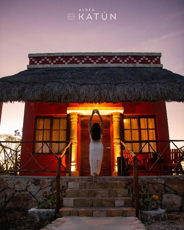 a house with a statue of a person standing in front of it at Hotel Aldea Katún in Izamal
