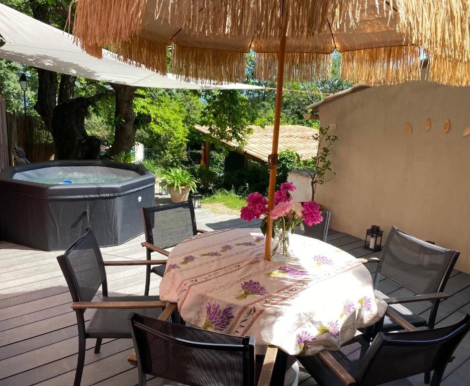- une table avec un vase de fleurs sur la terrasse dans l'établissement Maison Agatha, à La Garde-Freinet