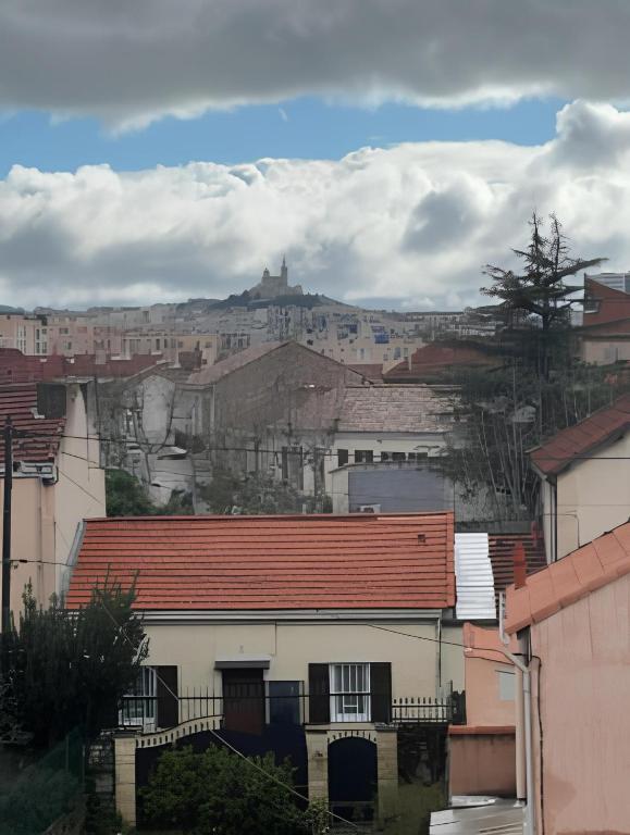 une ville avec des bâtiments et une colline en arrière-plan dans l'établissement T3 résidence fermée avec parking, à Marseille