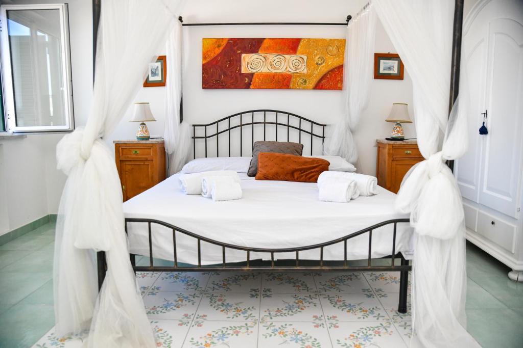a bedroom with a bed with white curtains at Fantasy House Apartaments in Forio d'Ischia