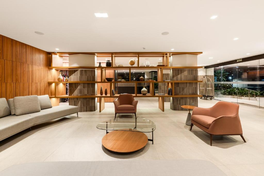 a living room with a couch and chairs at Hotel Trianon Paulista in Sao Paulo