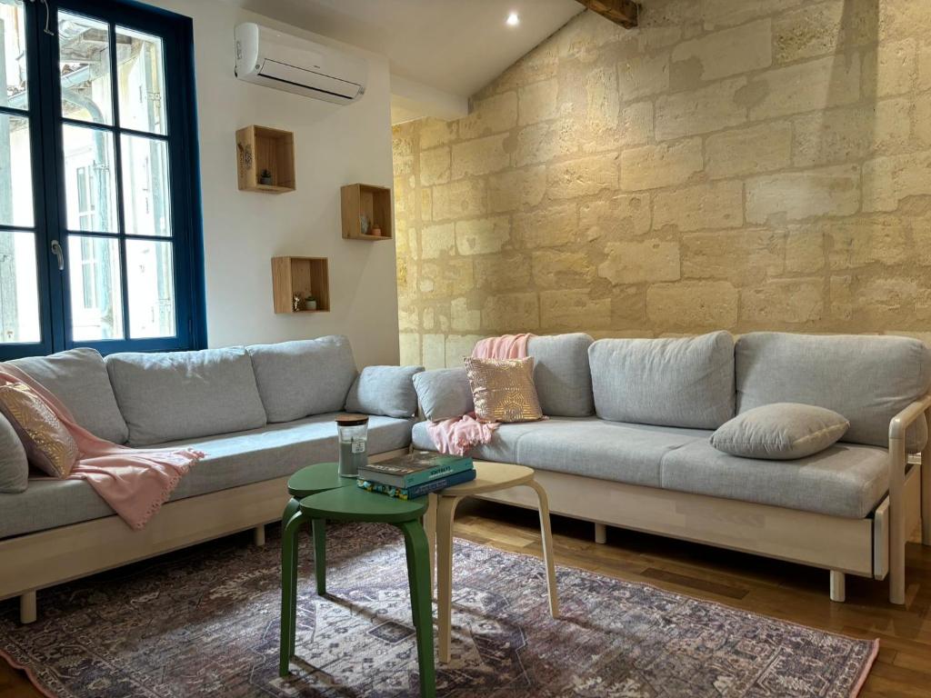 a living room with a couch and a table at Grand appartement climatisé en plein centre de Bordeaux Place Fernand Lafargue in Bordeaux