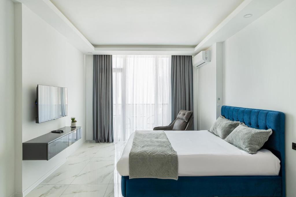 une chambre d'hôtel avec un lit et une télévision dans l'établissement GG LuxLiving at Panorama Beach, à Batoumi