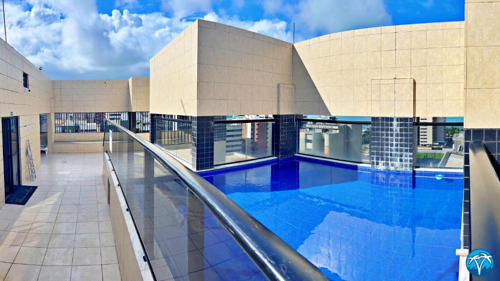 a swimming pool in front of a building at Vacanze - Barão de Mauá in Maceió