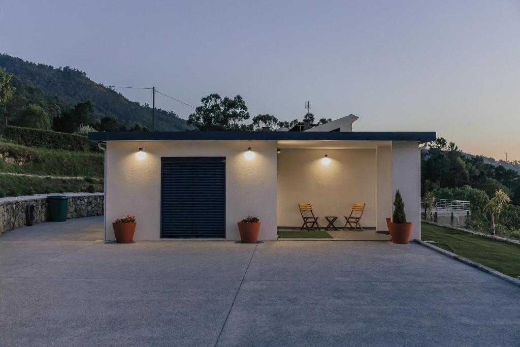 a small house with two chairs on a patio at Villa Cantinho da Cavadinha in Arouca