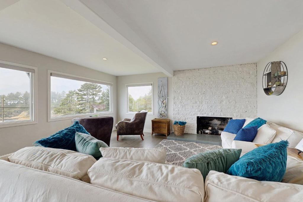 a living room with a white couch and a fireplace at Gracie's Sea View in Depoe Bay