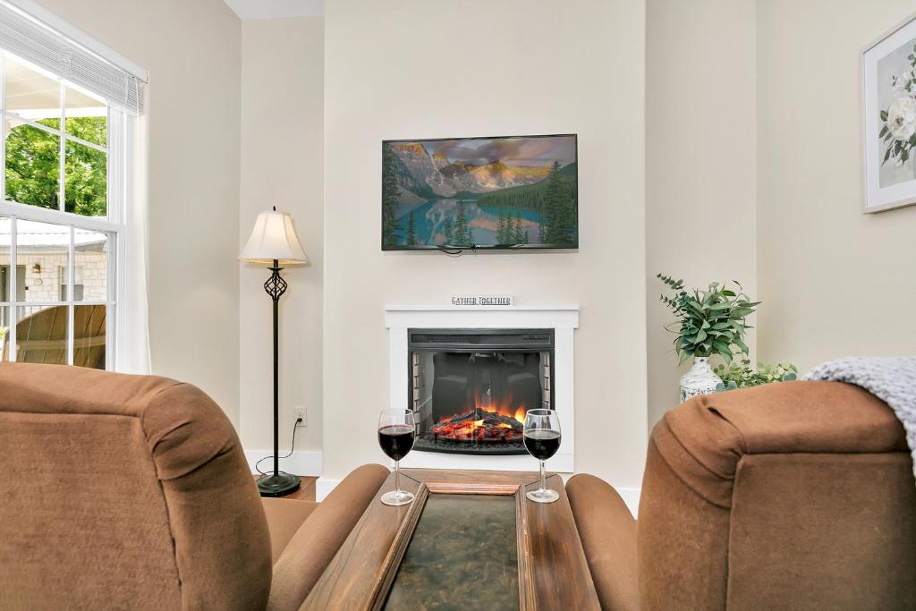 una sala de estar con chimenea y 2 copas de vino en Main Street Retreat #16 - King Bed, On Main St, Shared Hot Tub & Pool, en Fredericksburg