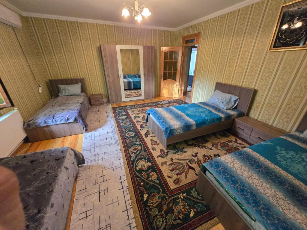 Un dormitorio con dos camas y una alfombra. en Heaven apartment, en Gabala