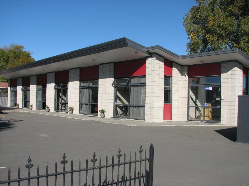 a red and white building with a fence in front of it at Kaiapoi on Williams Motel in Kaiapoi