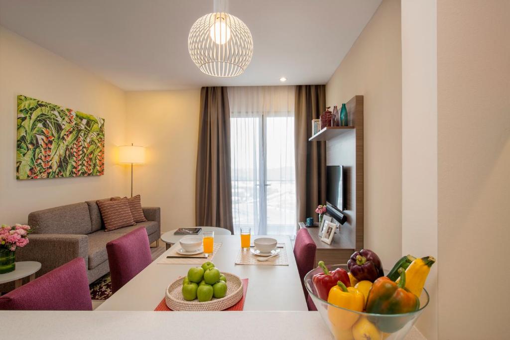 a living room with a table with a bowl of fruit at Somerset Medini Iskandar Puteri in Nusajaya