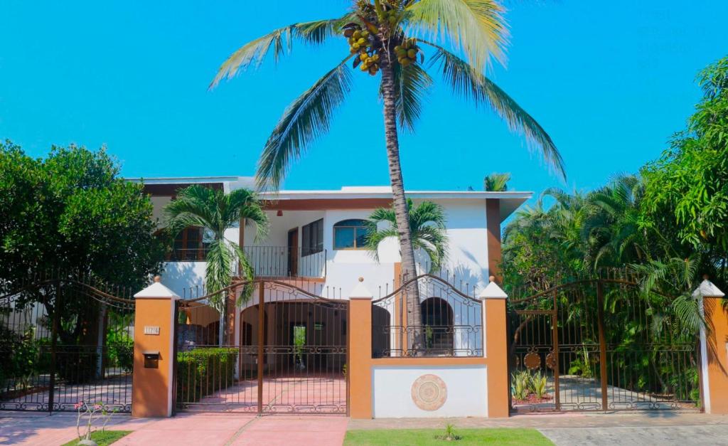 a palm tree in front of a house at Casa de los Abuelos con Jardín y vista al Canal in Nuevo Vallarta 