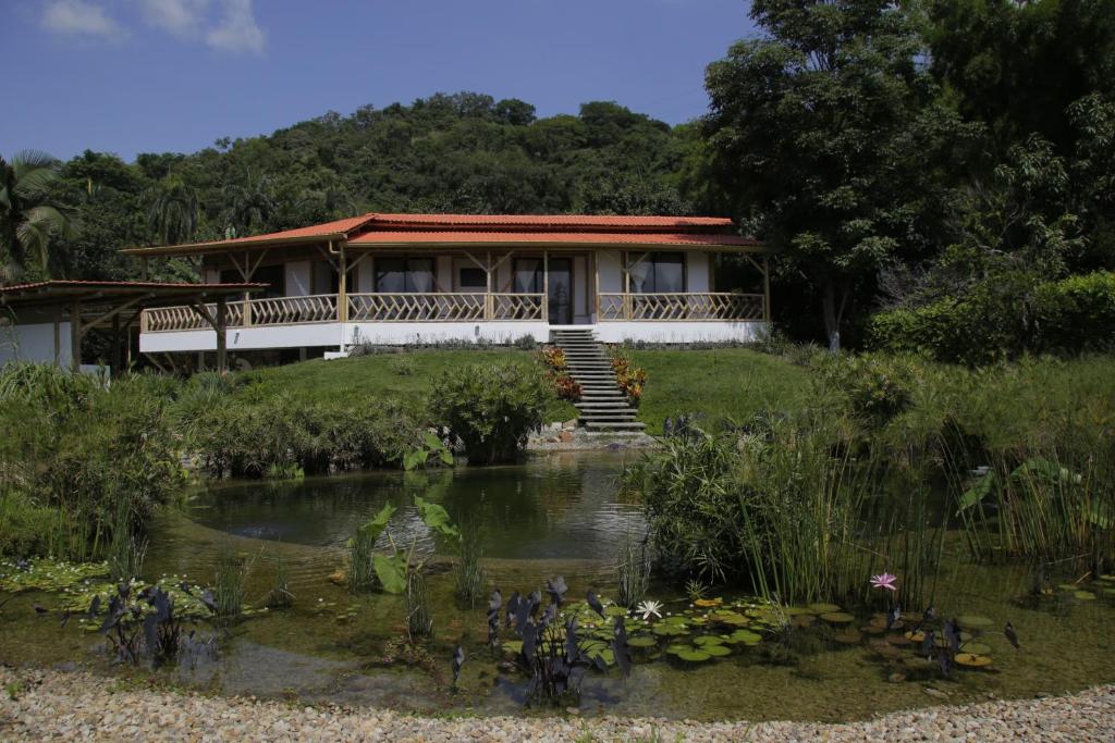 a house with a pond in front of it at Guaduas de Jade Casa campestre in La Mesa