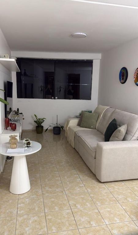ein Wohnzimmer mit Sofa und Tisch in der Unterkunft Apartmento São João in Campina Grande