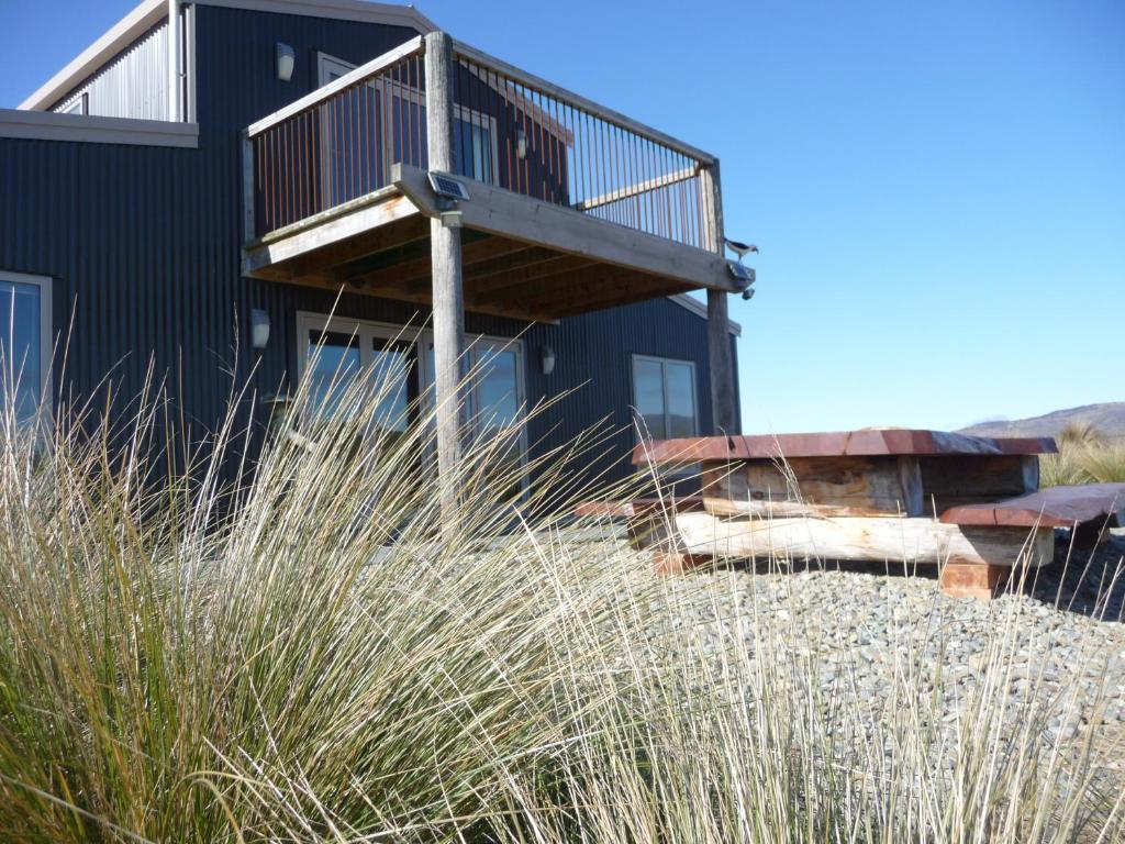 una casa en la playa con hierba alta en Tussock Lodge - Waipiata, en Waipiata