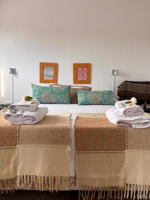 a large bed with towels on top of it at Soya Departamentos PB A in Junín
