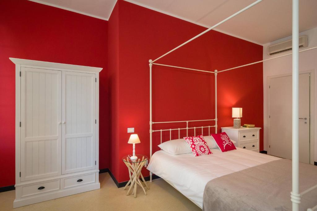 a bedroom with red walls and a bed with a canopy at Cinque Terre Moneglia Apartments in Moneglia