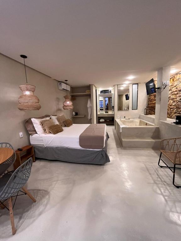 a bedroom with a bed and a bathtub and a tub at Casas Oba in Morro de São Paulo