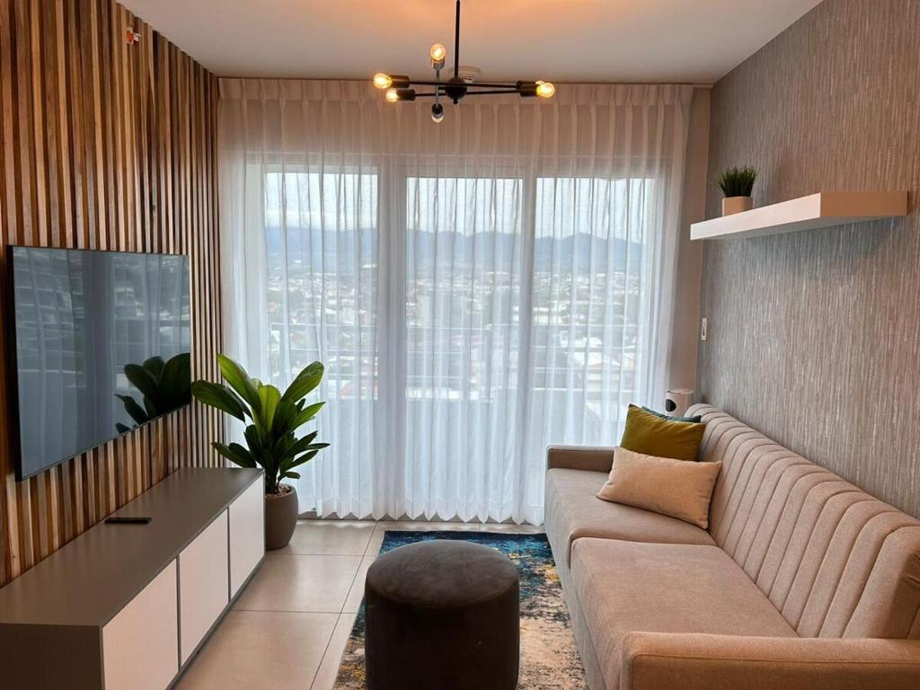 a living room with a couch and a large window at Luxury 1BR Condo Stunning Views in San José