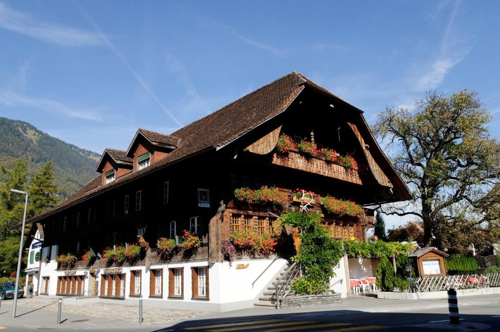 un edificio con cajas de flores en su lado en Hotel Restaurant Hirschen en Interlaken