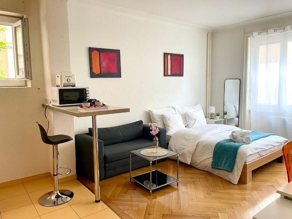 a bedroom with a bed and a couch at Down Town Studio in Lausanne