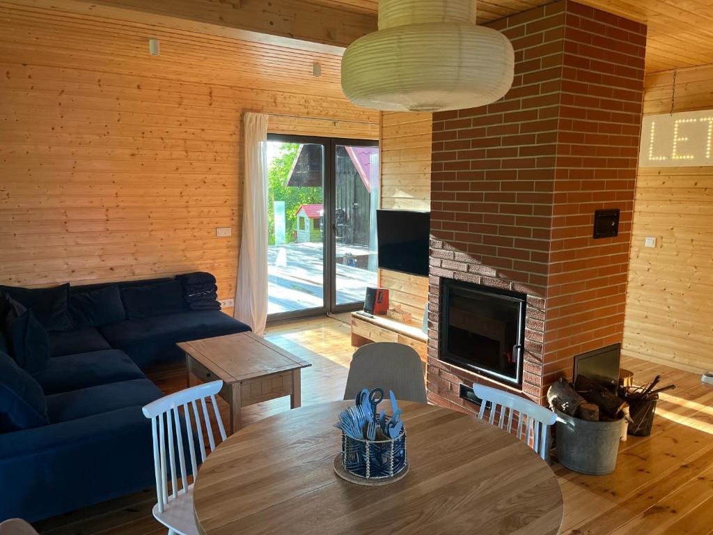 a living room with a table and a blue couch at Dom na Perłowej in Kopalino