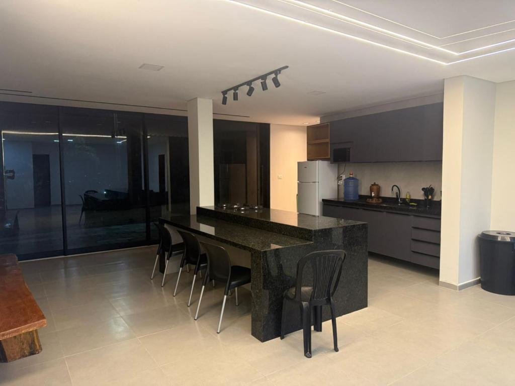 una cucina con bancone nero e sedie di Sua Casa Na Serra 2 a Bezerros