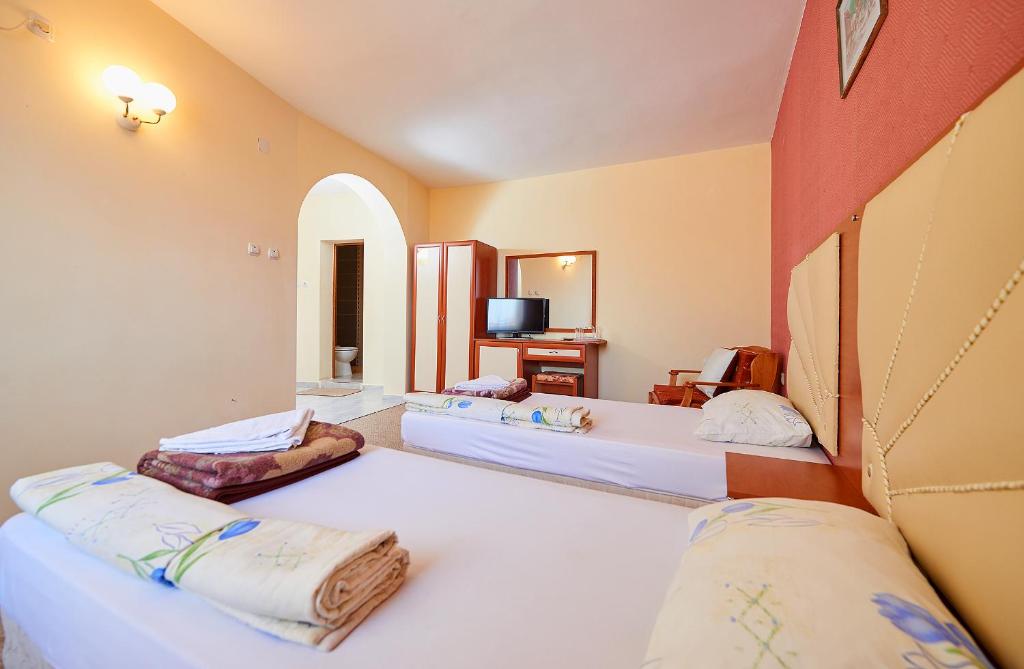 A bed or beds in a room at Peneka Hotel