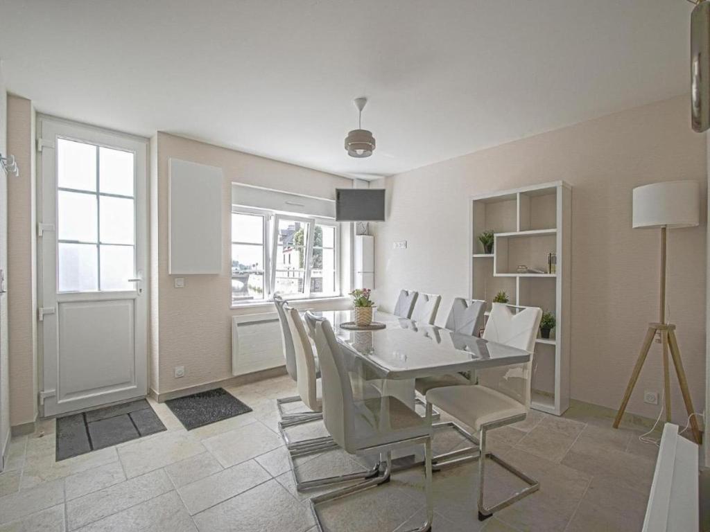 une salle à manger blanche avec une table et des chaises dans l'établissement Holiday Home in Isigny-sur-Mer with Garden, cleaning included, à Isigny-sur-Mer