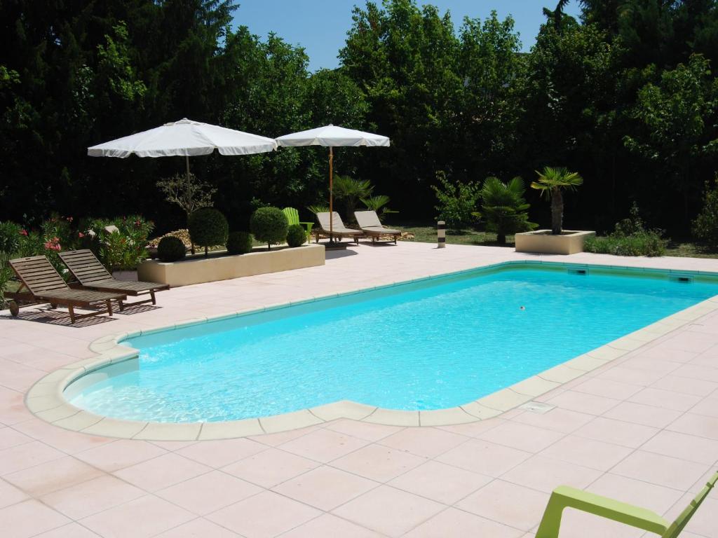 une grande piscine avec chaises et parasols dans l'établissement Country House in Provence with Garden Access, cleaning included, à Valréas