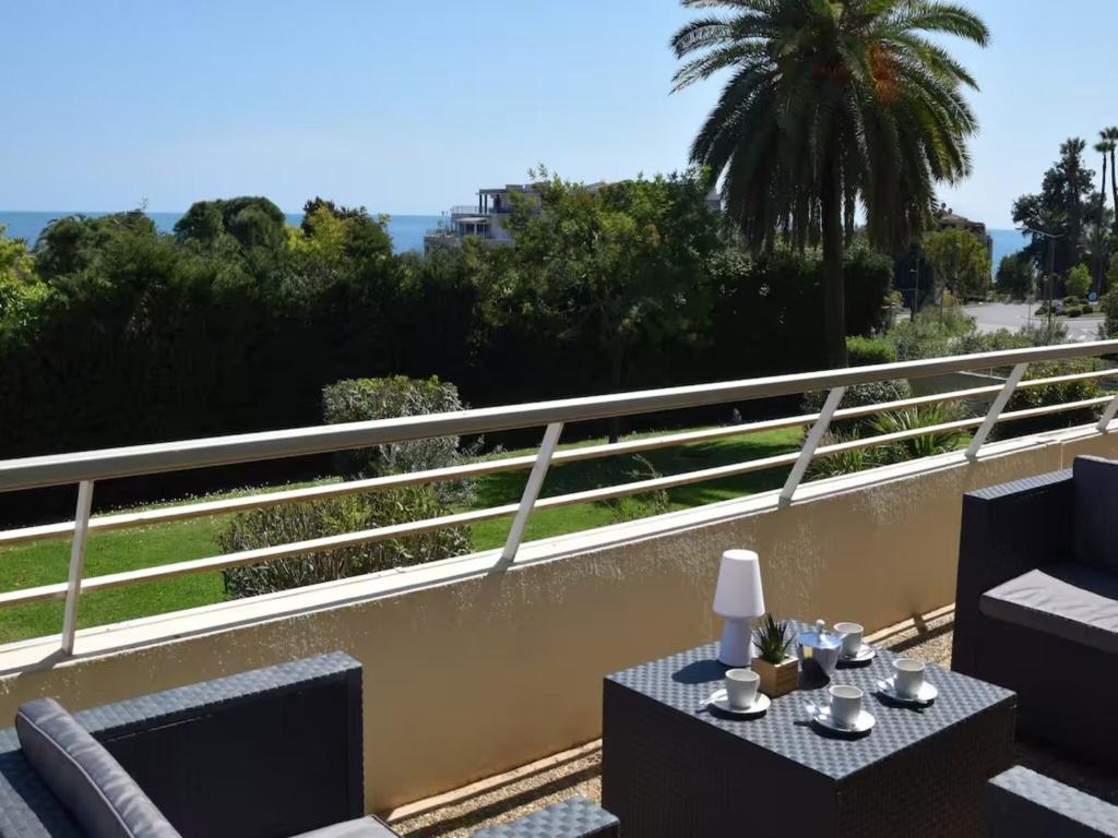 un patio avec une table et des chaises sur un balcon dans l'établissement Apartment in Golfe Juan with Sea View, cleaning included, à Vallauris