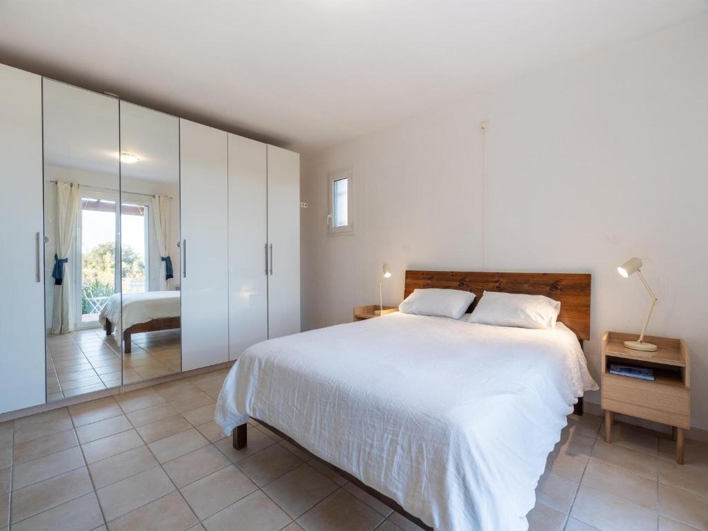 une chambre avec un grand lit blanc et un miroir dans l'établissement Holiday Home in Occitanie with Private Pool, cleaning included, à Félines-Minervois