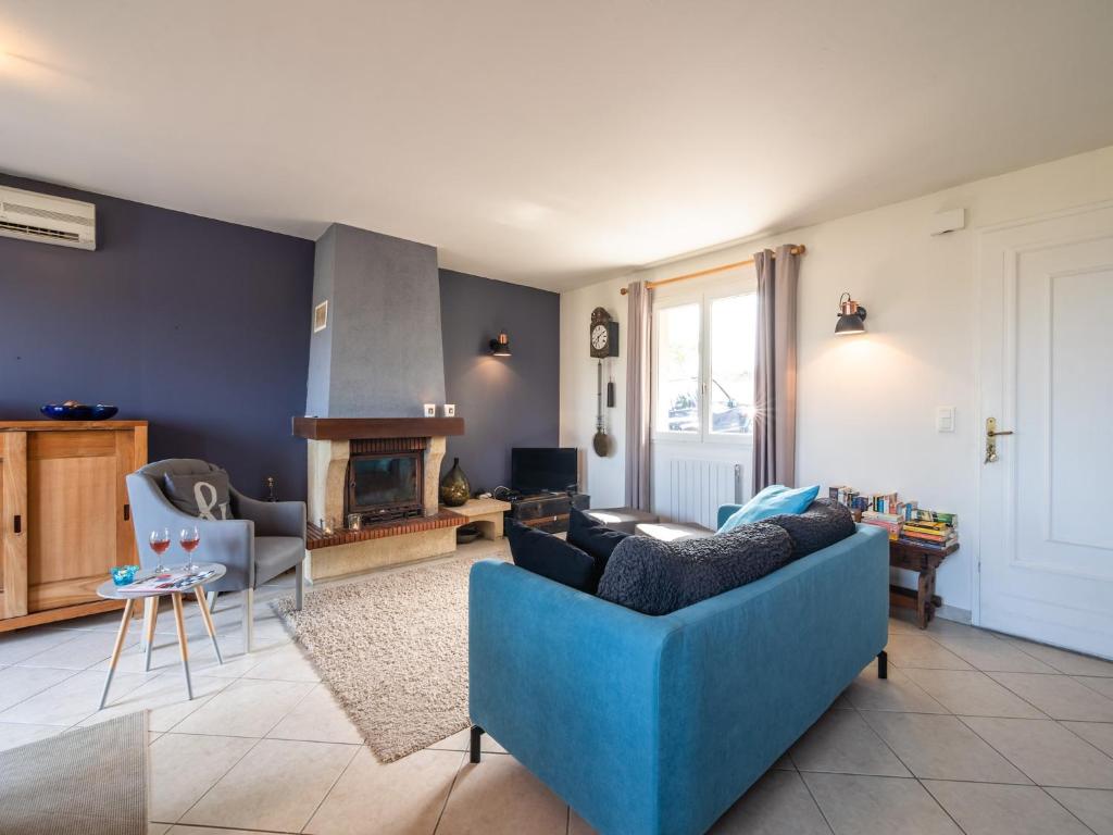 un salon avec un canapé bleu et une cheminée dans l'établissement Villa in Caunes-Minervois with Private Pool, cleaning included, à Caunes-Minervois