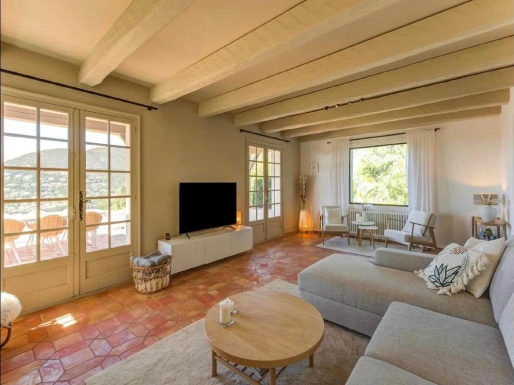 un salon avec un canapé et une télévision dans l'établissement Villa in Cavalaire with Sea View & Pool, cleaning included, à Cavalaire-sur-Mer