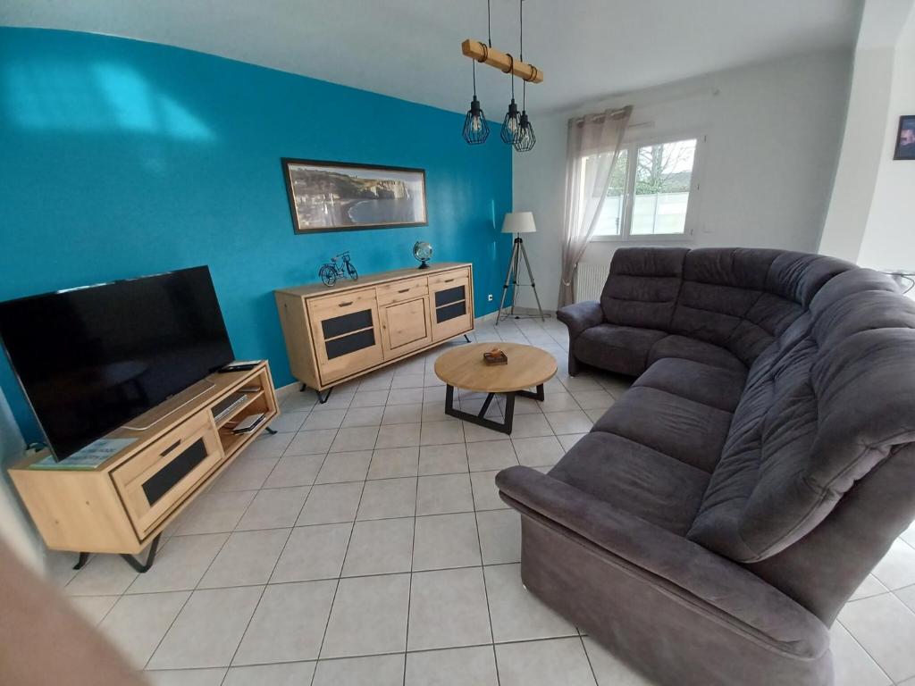 un salon avec un canapé et une télévision à écran plat dans l'établissement Holiday Home in Normandy near the Sea, cleaning included, à Étretat