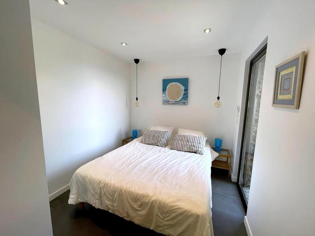 une chambre avec un lit blanc avec deux oreillers dans l'établissement Villa in Gaou with Sea View and Beach, cleaning included, à Bormes-les-Mimosas