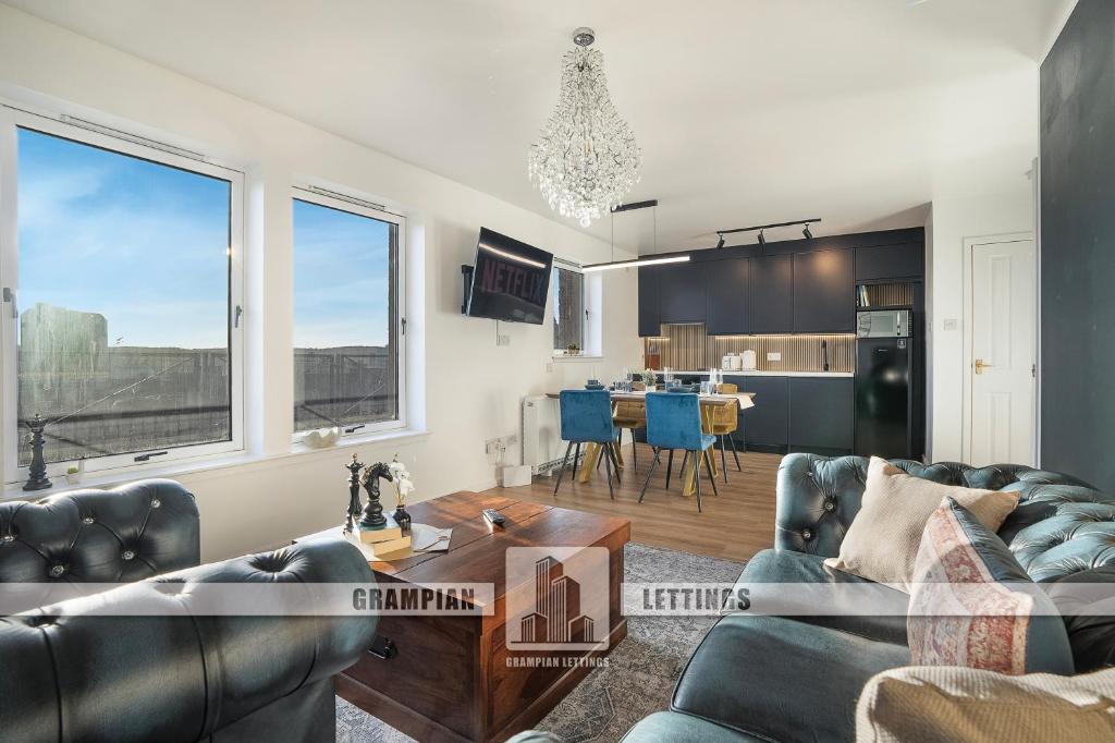 Una sala de estar con dos sofás y una cocina. en The Tarantino - Grampian Lettings, en Aberdeen