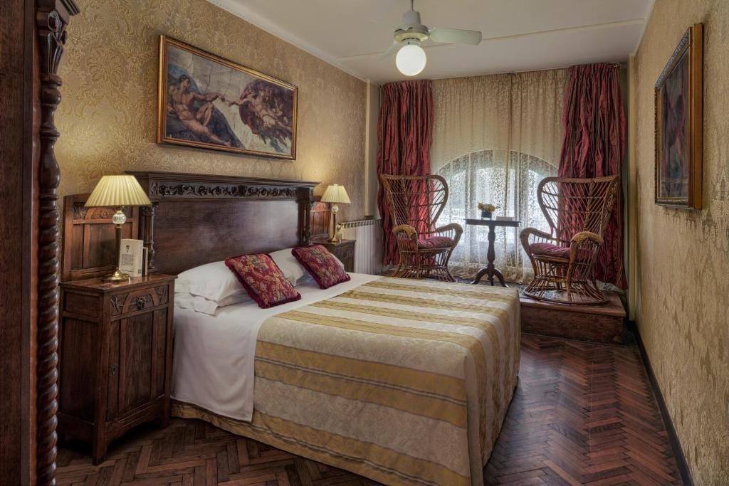 威尼斯的住宿－加勒里亞酒店，一间卧室配有一张大床和两把椅子