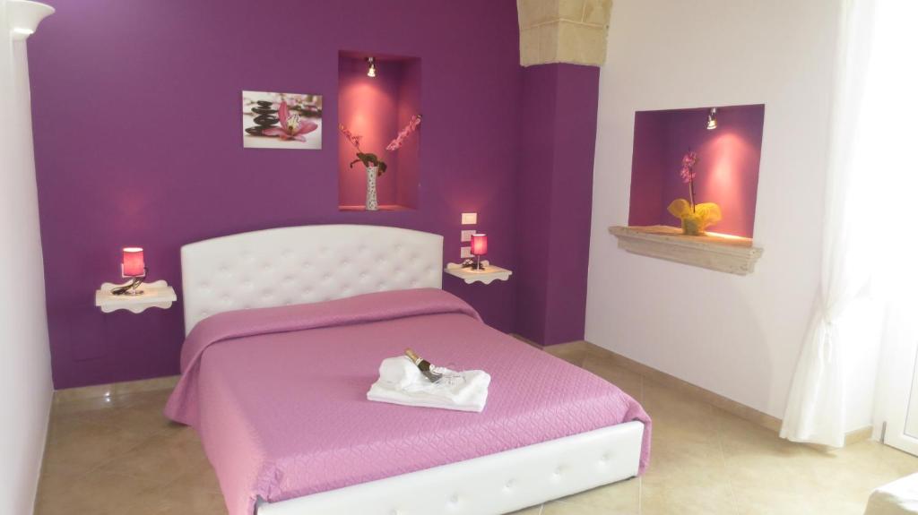 una camera da letto viola con un letto con una coperta viola di Antico Casale B&B a Veglie
