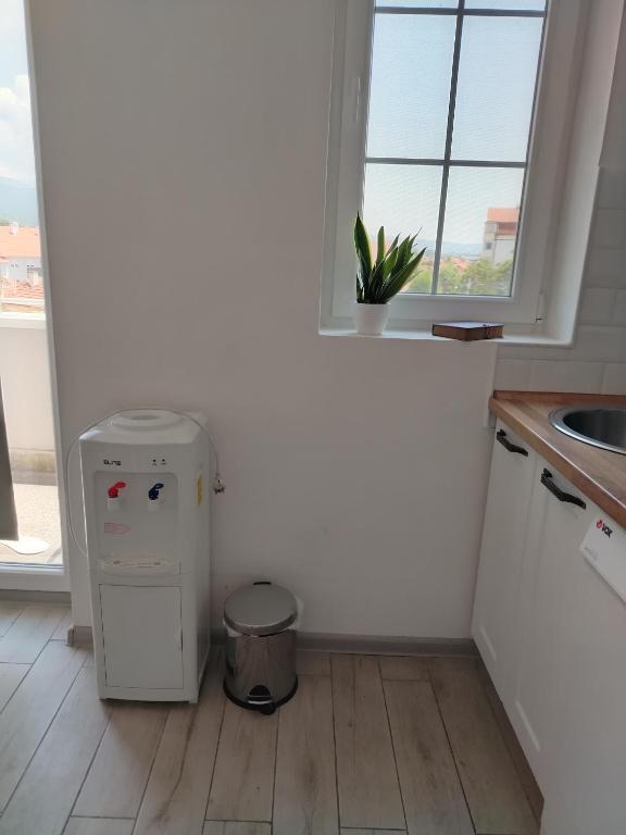 a small refrigerator in a kitchen with a window at Apartman REA 1 in Pirot