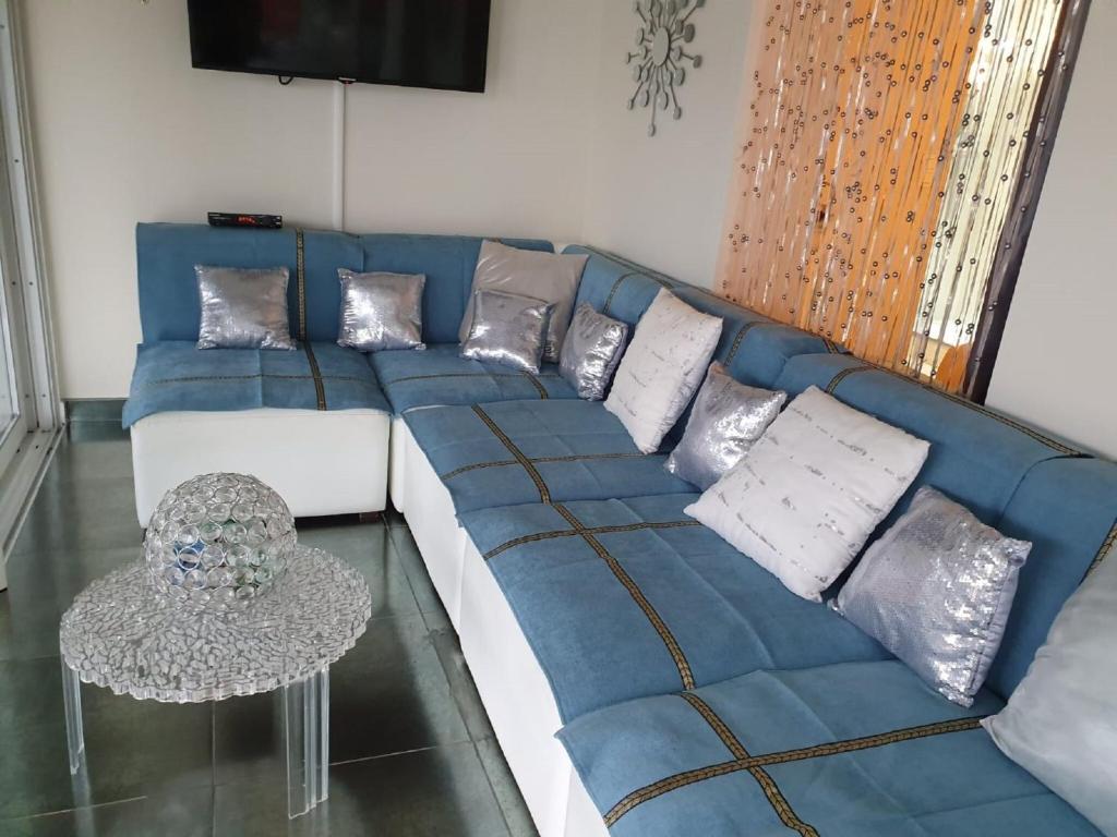 un canapé bleu et blanc avec des coussins et une table dans l'établissement Village House in France with Private Pool, cleaning included, à Bagnols-en-Forêt