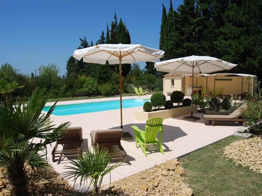 une terrasse avec des chaises et des parasols ainsi qu'une piscine dans l'établissement Mansion in Provence with Pool & Near Town, cleaning included, à Valréas