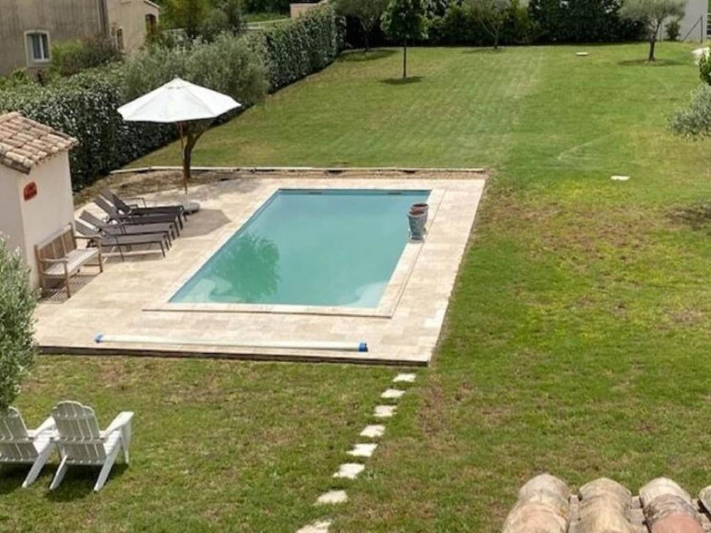 - une piscine dans une cour avec des chaises et un parasol dans l'établissement Holiday Home in Pougnadoresse with Pool, cleaning included, à Pougnadoresse