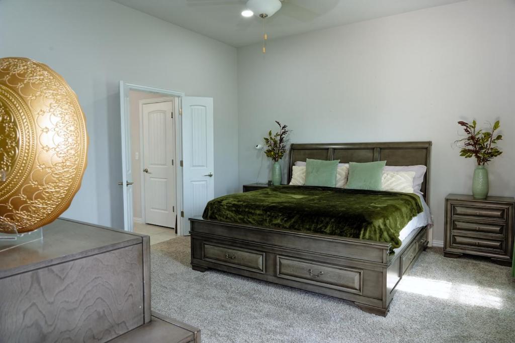 a bedroom with a bed with a green comforter at Family Escape - King Size Suites - plus Fast Wifi in Austin
