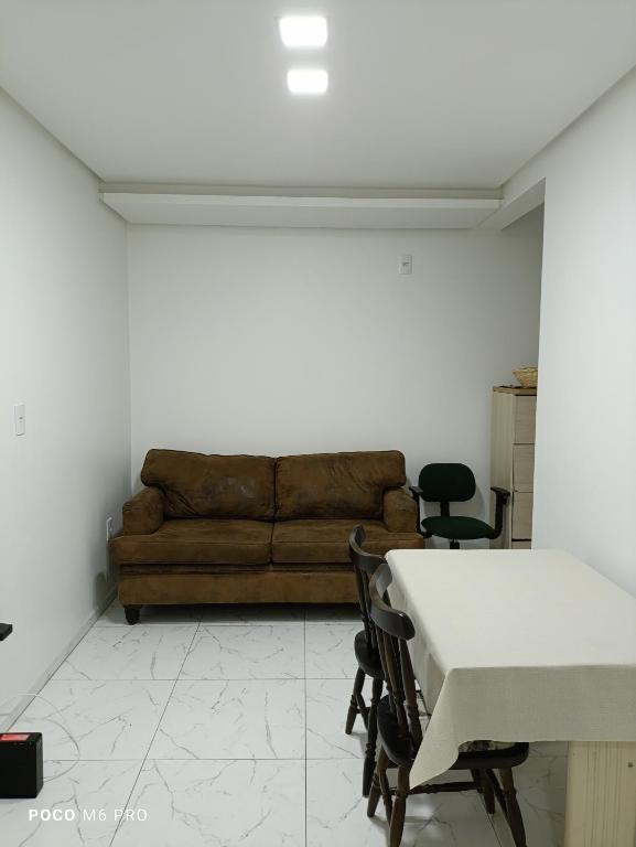 een woonkamer met een bank, een tafel en stoelen bij Apartamento central in Uruguaiana